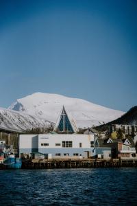 特罗姆瑟Fjordbooking的一座教堂,其背景是一座白雪覆盖的山