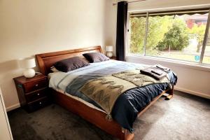 墨尔本Charming Home Near Melbourne Airport & CBD的一间卧室设有一张大床和一个窗户。