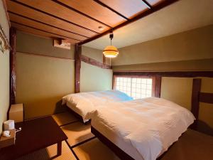 白马村古民家ホテル 結 YUWAI的卧室配有白色的床和窗户。