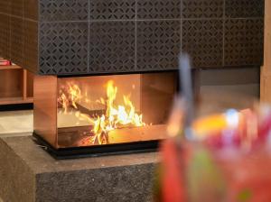 塞尔瓦迪加尔代纳山谷博匝玛尼格尼酒店的壁炉里的火,喝一杯苏打水