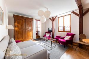 科尔马Au Bonheur des Anges Appartement 2 chambres avec terrasse的客厅配有白色沙发和紫色椅子