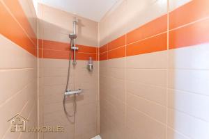 科尔马Au Bonheur des Anges Appartement 2 chambres avec terrasse的浴室铺有橙色和白色瓷砖,设有淋浴。