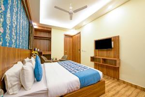 新德里Presedent Airport Hotel Near Delhi International Airport的一间卧室配有一张床和一台平面电视