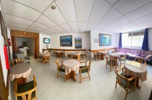 桑特佩尔佩斯卡多尔Hotel El Pescador的用餐室配有桌椅和沙发