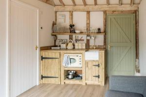 贝克尔斯4 Henham Barns的一个带木制橱柜和门的小厨房