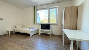 基尔Work&Stay Apartment - Kiel的小房间设有床和电视