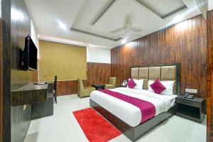新德里Hotel Seven Inns Qubic Near Delhi Airport的一间卧室配有一张红色地毯的大床