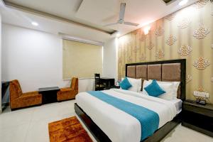 新德里Hotel Seven Inns Qubic Near Delhi Airport的一间卧室配有一张大床和一把椅子