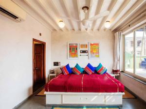 艾哈迈达巴德Mangaldas Ni Haveli II by The House of MG的一间卧室配有红色的床和蓝色枕头