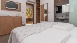 特罗吉尔特罗吉尔露西亚别墅公寓的卧室配有白色的床和水槽