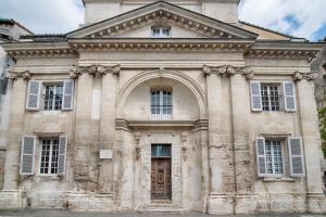 阿维尼翁La Chapelle du Miracle的一座带窗户和门的大型石头建筑