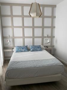 马拉加罗马剧院精品酒店的一间卧室配有一张带蓝色枕头的大床