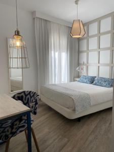 马拉加罗马剧院精品酒店的卧室配有床、椅子和窗户。