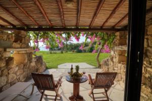 珊瑚湾塞浦路斯珊瑚海滩酒店和度假胜地的一个带桌椅和石墙的庭院