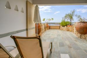 珊瑚湾塞浦路斯珊瑚海滩酒店和度假胜地的客房设有带椅子和遮阳伞的阳台。