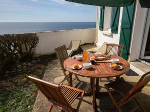 克拉斯卡诺特Holiday Home Les Roches - LPU 103 by Interhome的海景露台上的一张木桌和椅子