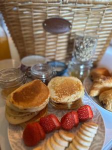 TalaisCôte & Lodge的桌上放有煎饼和草莓的盘子