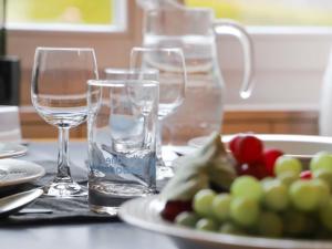 格施塔德Apartment Suzanne Nr- 21 by Interhome的桌子上放两杯水和一盘水果