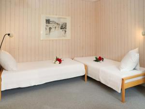 格施塔德Apartment Suzanne Nr- 21 by Interhome的两张床位于带鲜花的房间