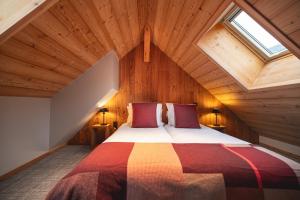 蒙乃第耶-勒潘Alliey & Spa Piscine Appart-hôtel Serre chevalier的一间卧室设有一张带木制天花板的大床
