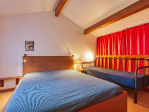 拉卡诺奥肯Holiday Home Les As-2 by Interhome的一间卧室设有两张床和红色窗帘
