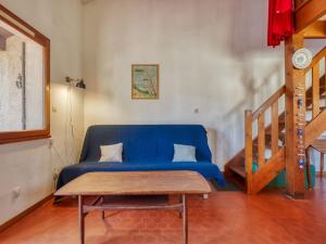拉卡诺奥肯Holiday Home Les As-2 by Interhome的客厅配有一张蓝色的沙发,配有木桌