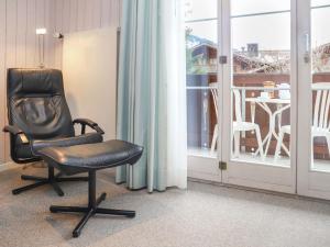 格施塔德Apartment Arlette Nr- 34 by Interhome的坐在窗前的一张黑椅子