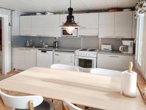 KöngäsHoliday Home Mukan maja by Interhome的厨房配有木桌和白色橱柜。