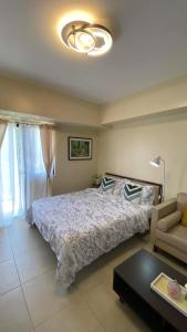 大雅台Condo Unit near Ayala Serin Mall的一间卧室配有一张大床和一张沙发