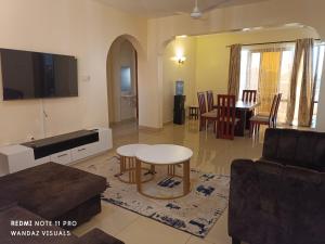 蒙巴萨Elegant furnished rooms with swimming pool in Nyali的客厅配有桌子和电视