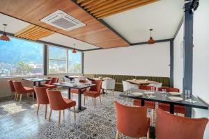 瑞诗凯诗Levelup Plus Pinaaki Inn的餐厅设有桌椅和大窗户。