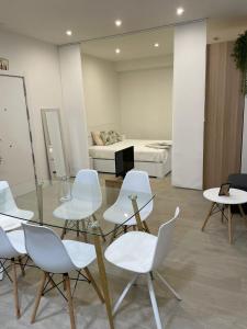 马德里Exyca Tetuán的一间设有玻璃桌和白色椅子的房间