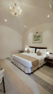 AyodhyaAyodhya haat Luxury Cottages的一间卧室配有一张大床和一个吊灯。