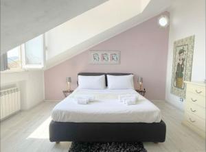 萨沃纳Mansarda Vista Mare a Zinola的白色卧室配有一张带白色床单的大床