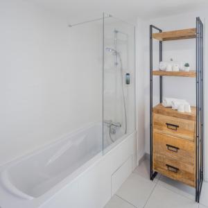 勒阿弗尔All Suites Appart Hotel Le Havre的带淋浴的浴室和木质梳妆台