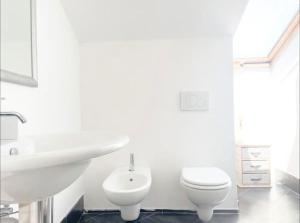 萨沃纳Mansarda Vista Mare a Zinola的白色的浴室设有卫生间和水槽。