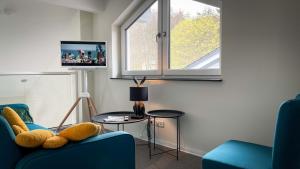 StipshausenANDERSWELTENlodge的客厅配有2把蓝色椅子和电视