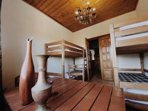 第比利斯Hostel Ocean的一间设有两张双层床的客房,木桌上摆放着两瓶花瓶