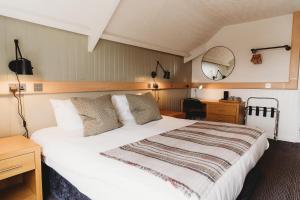 特鲁罗Hotel VARA的卧室配有一张白色大床和镜子