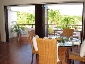 里奥格兰德Holiday Home at Rio Mar的阳台的用餐室配有桌椅