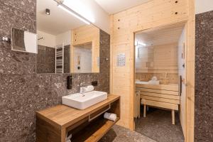 索内纳尔佩·纳斯费尔德Almresort Sonnenalpe Nassfeld by ALPS RESORTS的浴室配有白色水槽和浴缸。