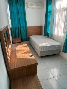 锡德ZÜMRÜT PANSİYON Side的卧室配有1张床、1张桌子和1把椅子