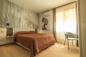 兰佩杜萨Hotel Nautic的卧室配有床、椅子和窗户。