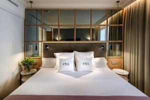 马德里巴塞罗帝国酒店的卧室配有一张带两个枕头的大白色床