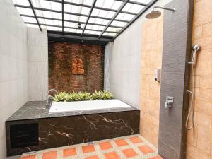 他朗巴立岩别墅的浴室配有带植物的浴缸。
