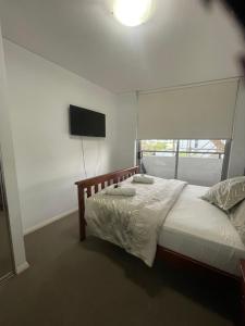 悉尼Ocean view 2 Bedroom apartment的一间卧室配有一张床和一台平面电视