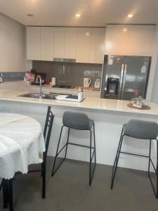 悉尼Ocean view 2 Bedroom apartment的厨房配有两把椅子和带水槽的台面