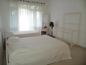 卡卢特勒Ananthaya -the infinity的一间白色卧室,配有两张床和窗户
