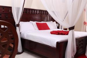 TezoWhite Peacock Resort的一间卧室配有一张带红色枕头和窗帘的床