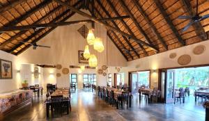 雾观Umbhaba Eco Lodge的一间大房间的餐厅,配有桌椅